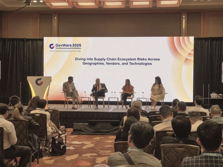 A panel on supply chain risk in front of a seated audience.